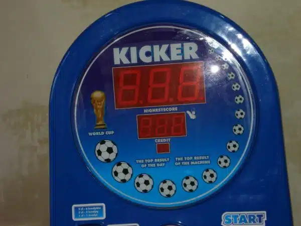 Automat piłkarski z wynikami i przyciskiem start.