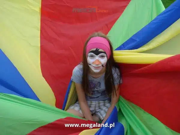 Dziewczynka z malowaniem twarzy na kolorowej tkaninie.