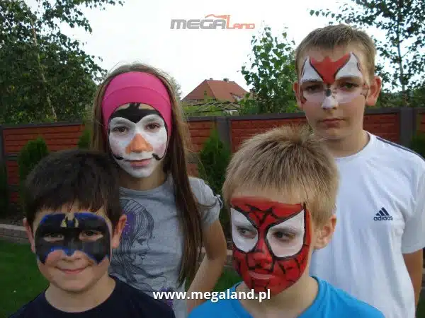 Dzieci z malowanymi twarzami na imprezie.