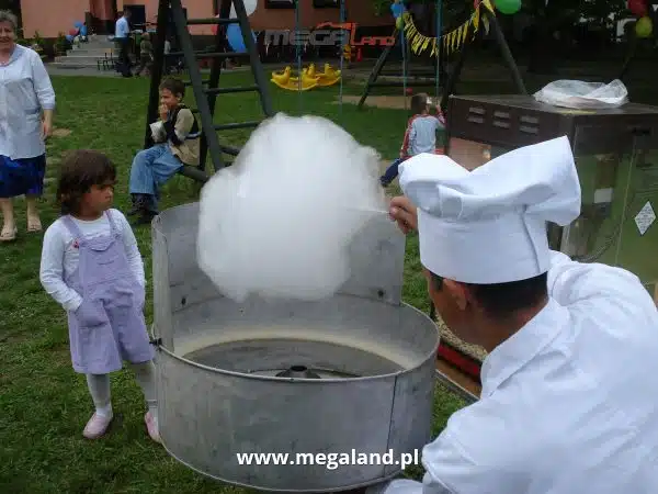 Cukiernik robi watę cukrową dla dzieci na festynie.