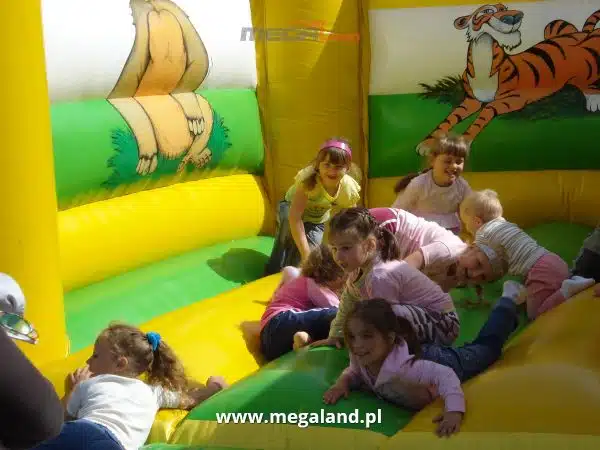 Dzieci bawiące się na dmuchanym zamku.