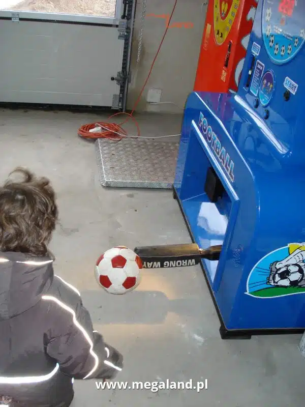 Dziecko gra w piłkarzyki na maszynie arcade.