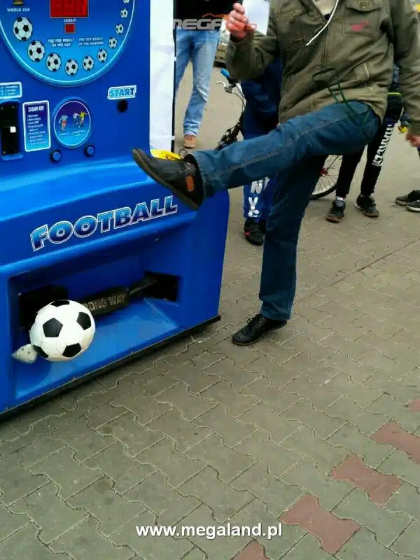 Osoba kopiąca piłkę w automacie piłkarskim.