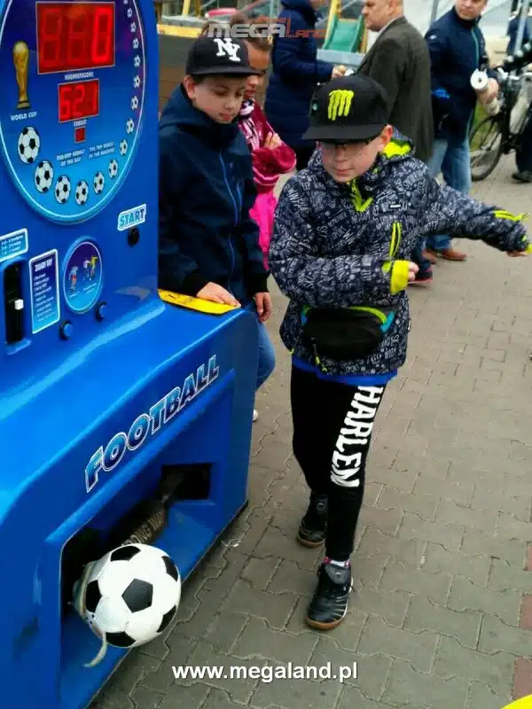 Dzieci grają w automat piłkarski na zewnątrz.