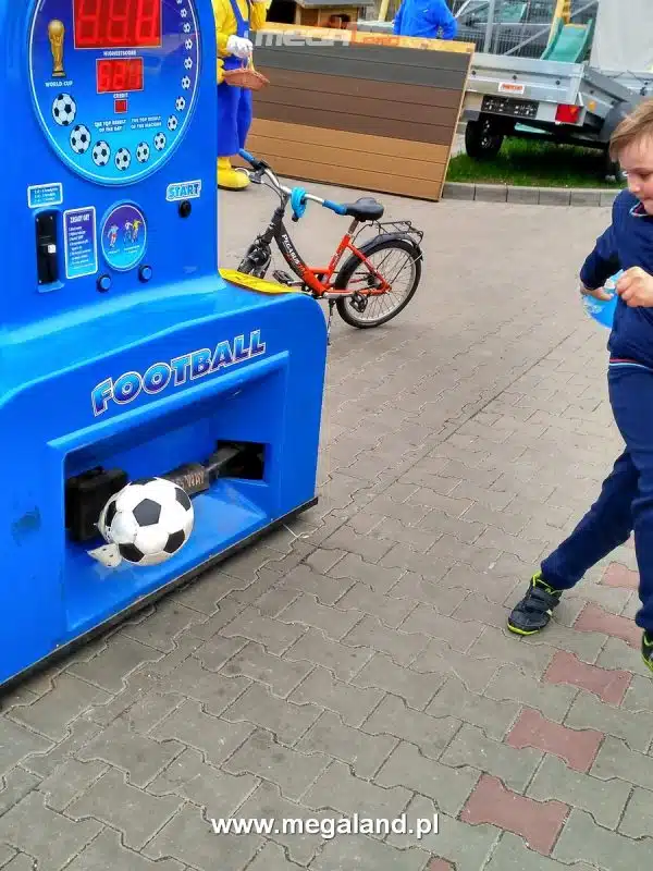 Dziecko grające na maszynie piłkarskiej na zewnątrz.