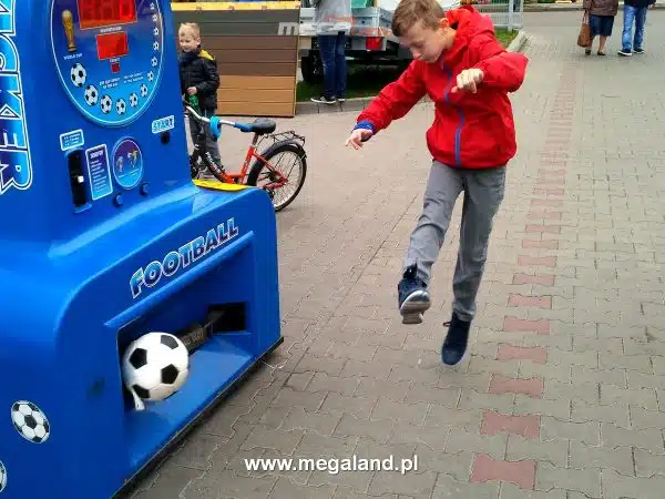 Chłopiec gra w automacie piłkarskim na zewnątrz.