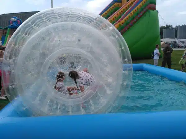 Dziecko bawi się w zorbingowej kuli na wodzie.