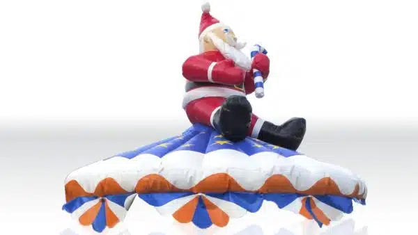 Karuzela Mikołaj w Megaland - świąteczny dekor z uśmiechniętym Mikołajem trzymającym laskę cukrową, na kolorowej dmuchanej karuzeli, doskonała na zimowe eventy dla dzieci.