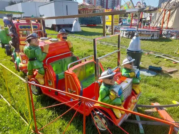 Pierwszy wagon Kolejki Elektrycznej w Megaland - w stylu strażackim, z wesołymi strażakami, przyciąga wzrok najmłodszych, oferując emocjonującą przejażdżkę.